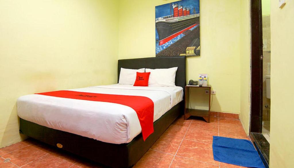 um quarto com uma cama grande e uma almofada vermelha em The Legian 777 em Legian
