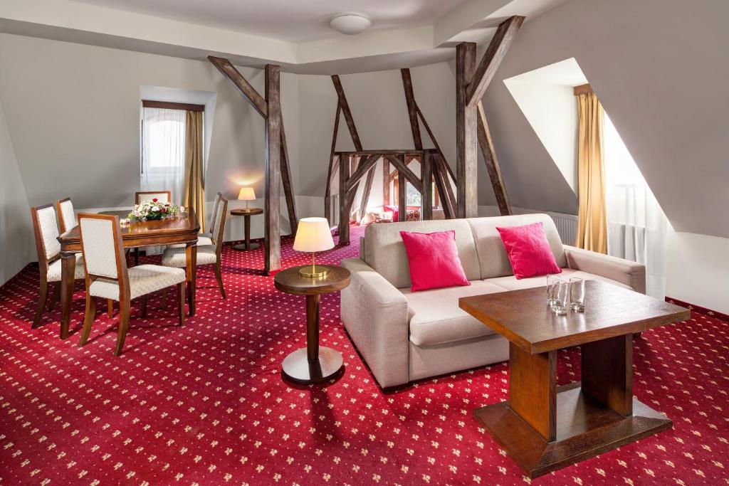 a living room with a couch and a table at Clarion Grandhotel Zlaty Lev in Liberec