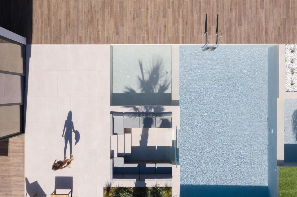 obraz osoby jeżdżącej na deskorolce obok basenu w obiekcie Mayana Luxury Villa, an infinite blue experience, by ThinkVilla w mieście Balíon