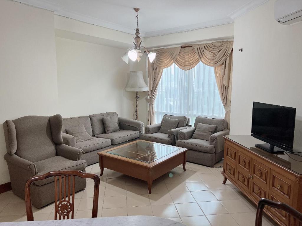 sala de estar con sofá y TV en Batavia apartements, en Yakarta