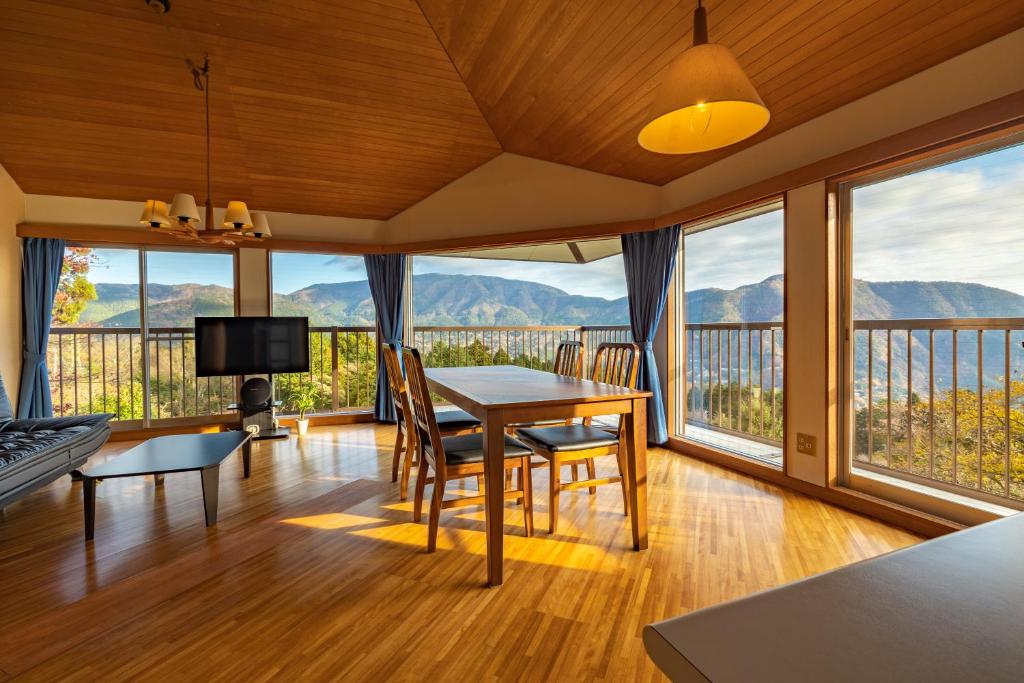 uma sala de estar com uma mesa e vistas para as montanhas em Gora Vacation em Hakone