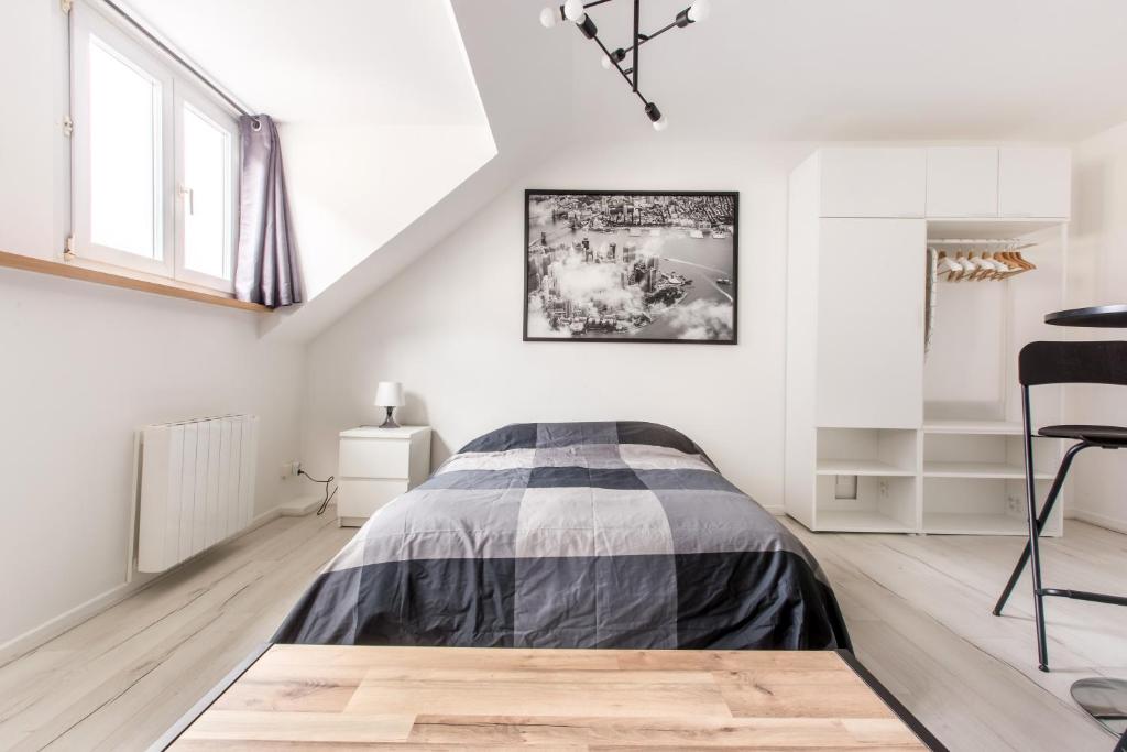 une chambre blanche avec un lit et une chaise dans l'établissement Studio New York, à Tourcoing