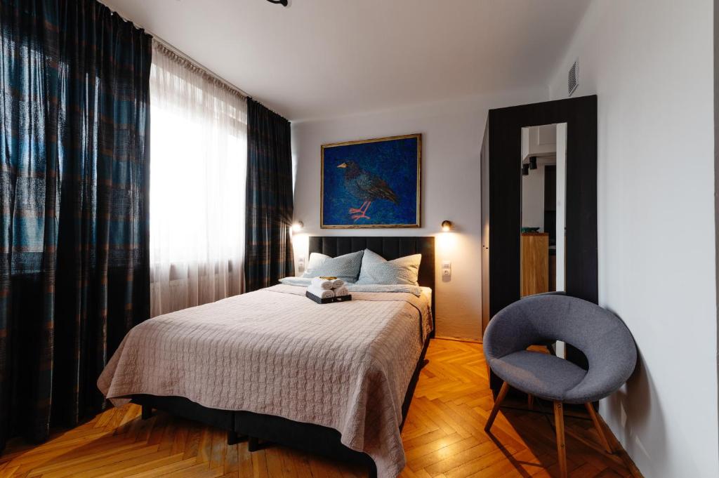 1 dormitorio con 1 cama y 1 silla azul en Kwiatowa Warsaw Apartment en Varsovia