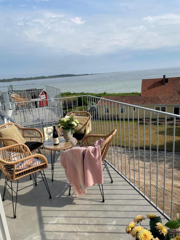 a balcony with chairs and a table and the beach at Hotell Hanöhus Hällevik in Sölvesborg