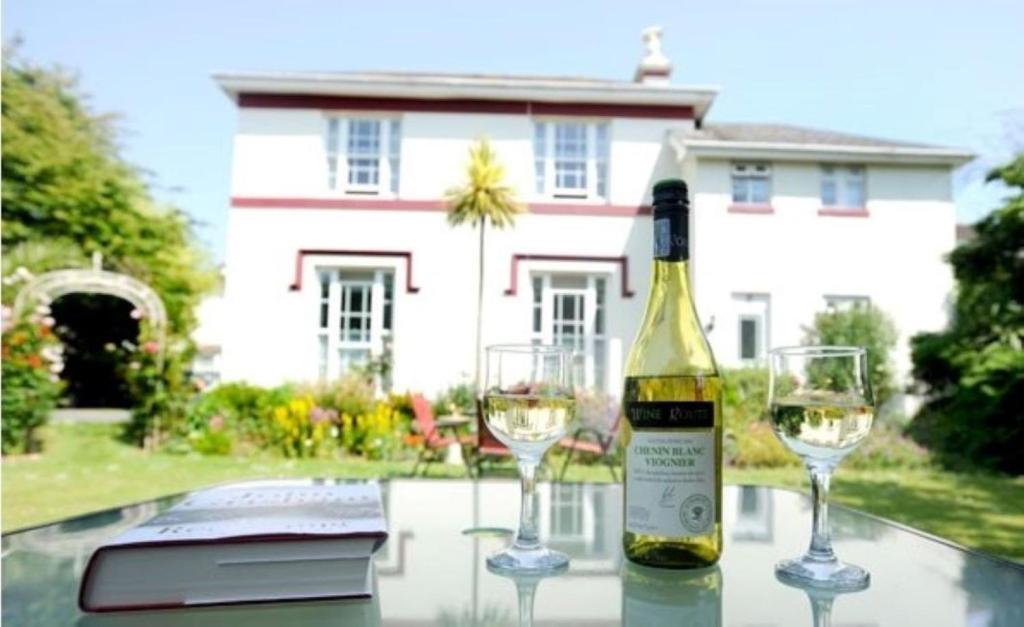 una bottiglia di vino e due bicchieri su un tavolo di Rose Court Holiday Apartments a Torquay