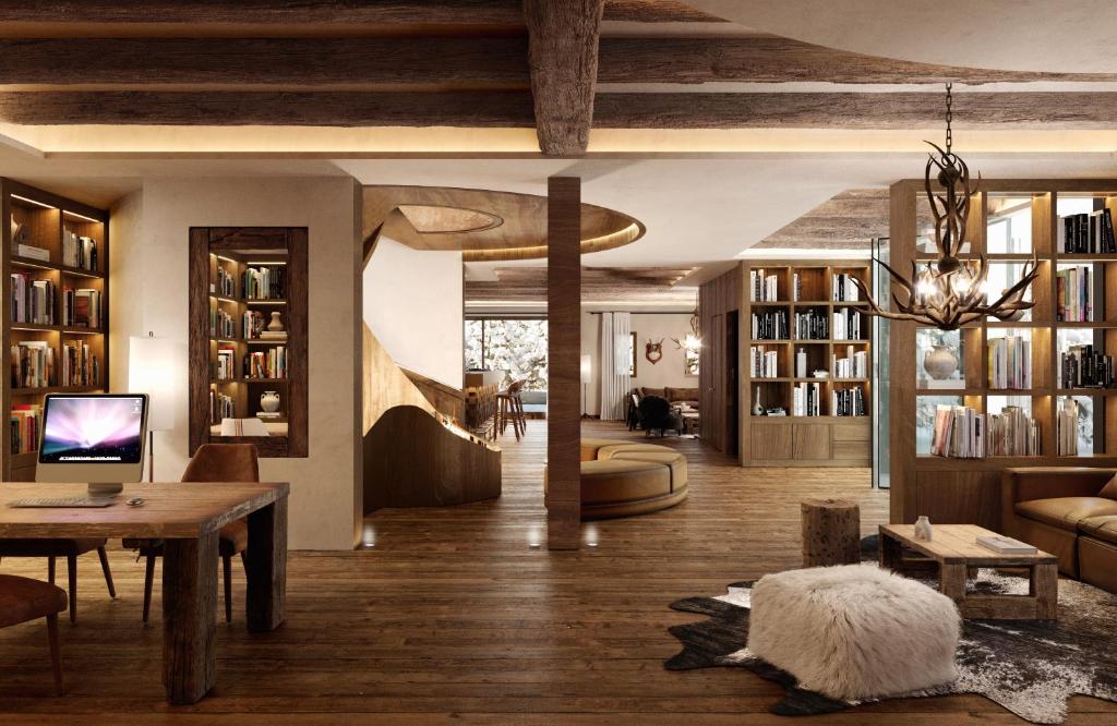 a living room with a table and bookshelves at Hotel Maribel in Sierra Nevada