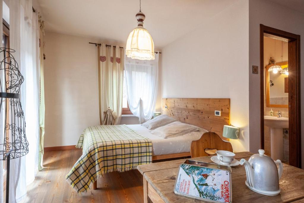 Dormitorio pequeño con cama y mesa en Maison Le Champ B&B Questa casa non è un albergo, en La Salle