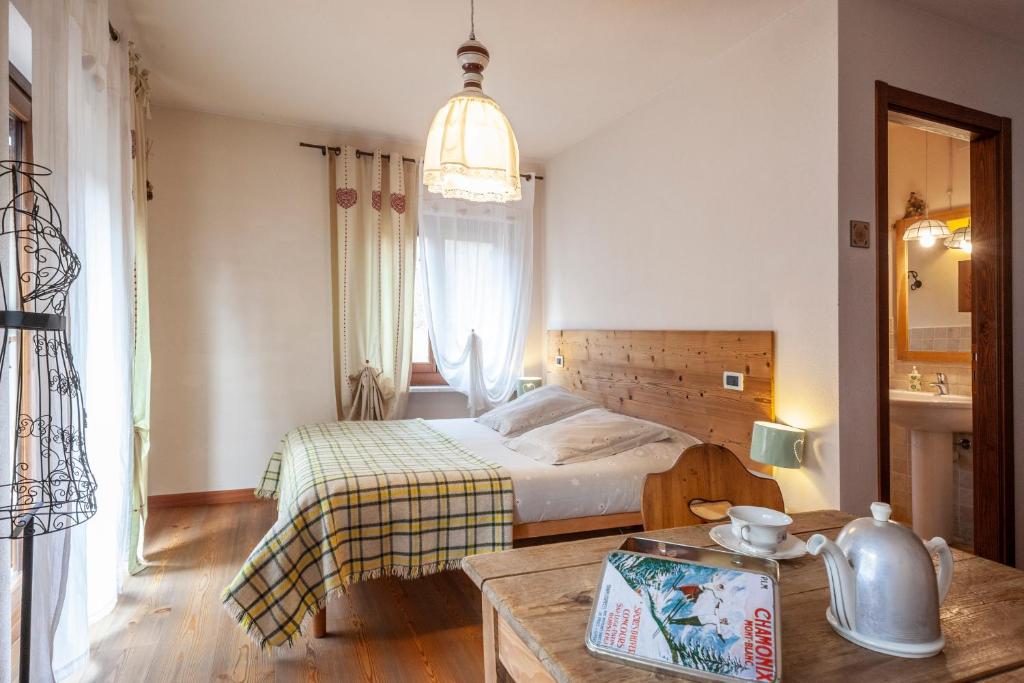 a small bedroom with a bed and a table at Maison Le Champ B&B Questa casa non è un albergo in La Salle