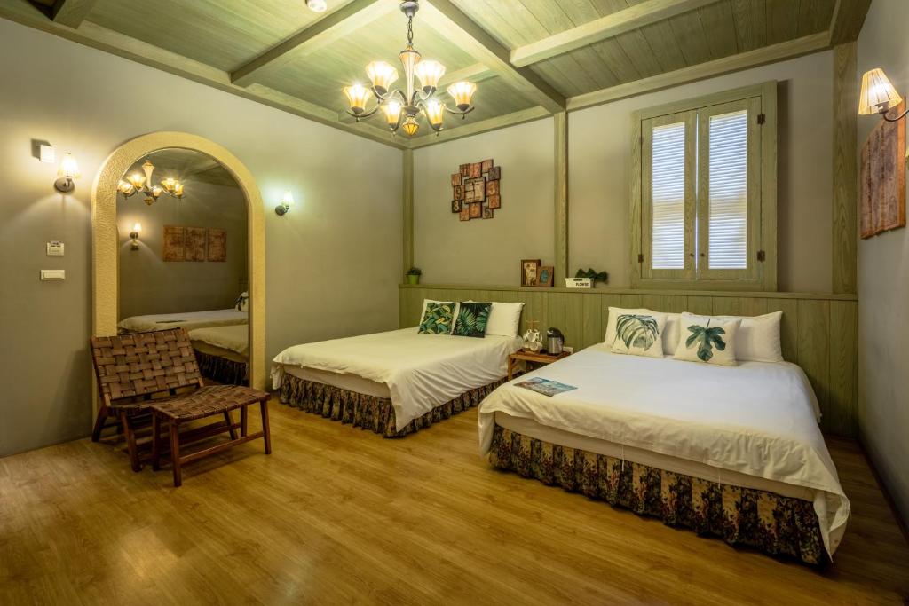 a bedroom with two beds and a mirror and a chair at Queen Love Homestay in Hualien City