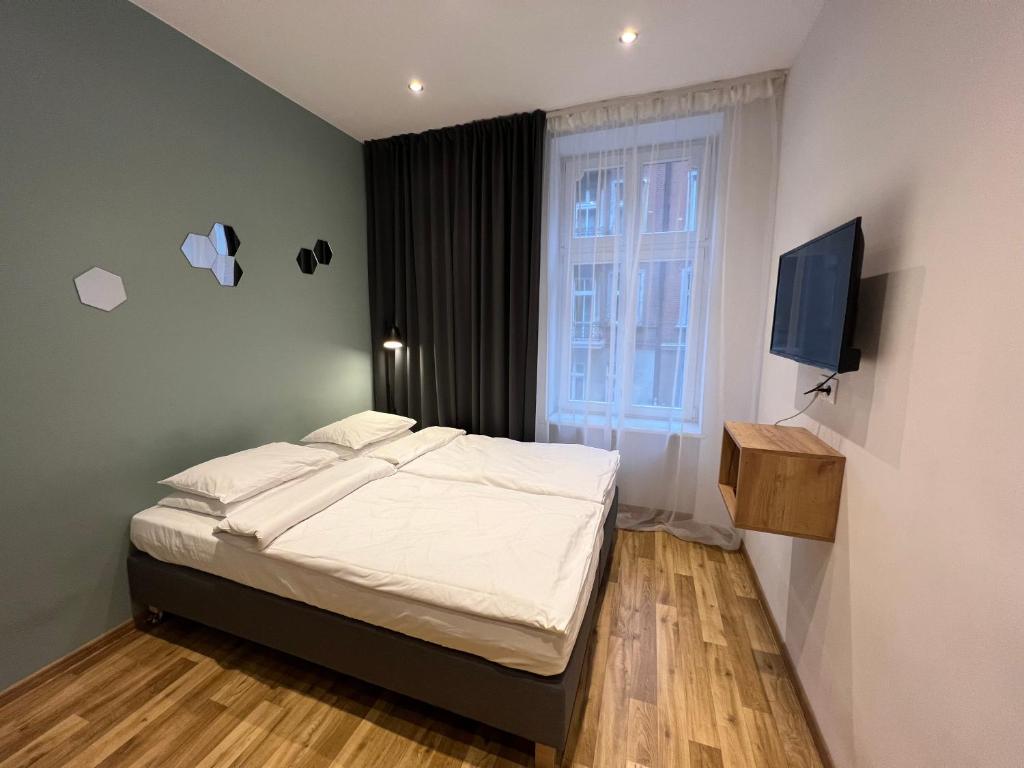- une petite chambre avec un lit et une télévision dans l'établissement Apartament Centrum Sienkiewicza, à Katowice