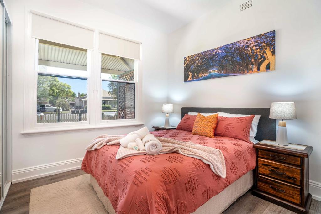 1 dormitorio con cama roja y ventana en One Bedroom Apartment on Summer/ No.2 near CBD en Orange