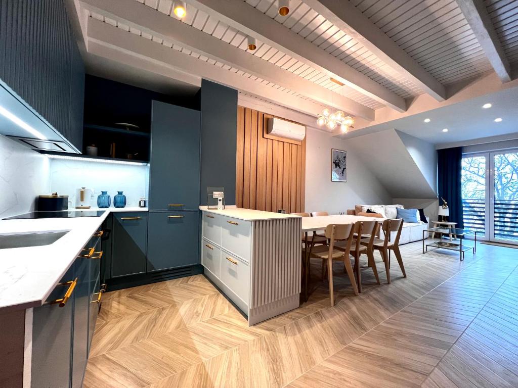 a kitchen and dining room with a table and chairs at Grand Apartament in Złotów