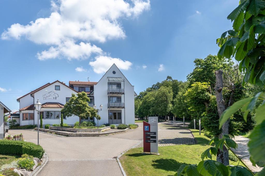 un bâtiment blanc avec un panneau devant lui dans l'établissement Gasthaus Hotel Zum Mohren, à Niederstotzingen