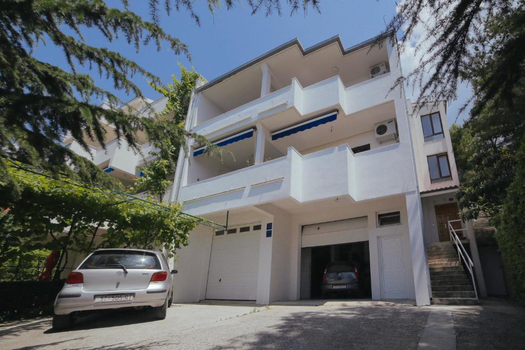 una casa con una macchina parcheggiata di fronte di Apartments Dada a Omiš (Almissa)