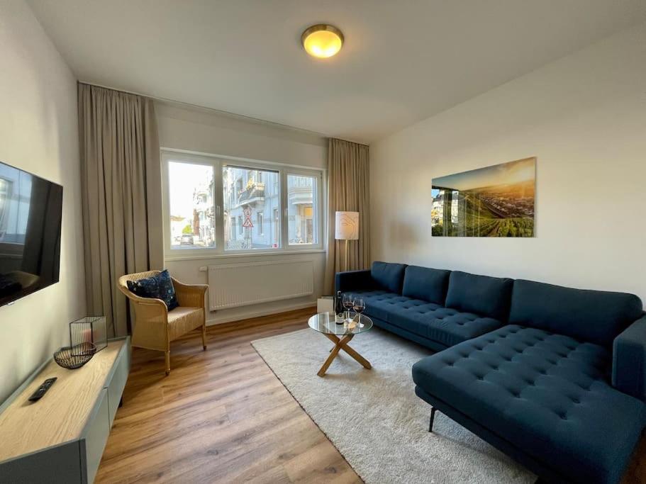 ein Wohnzimmer mit einem blauen Sofa und einem Tisch in der Unterkunft Ferienwohnung Freude am Kurpark in Bad Neuenahr-Ahrweiler