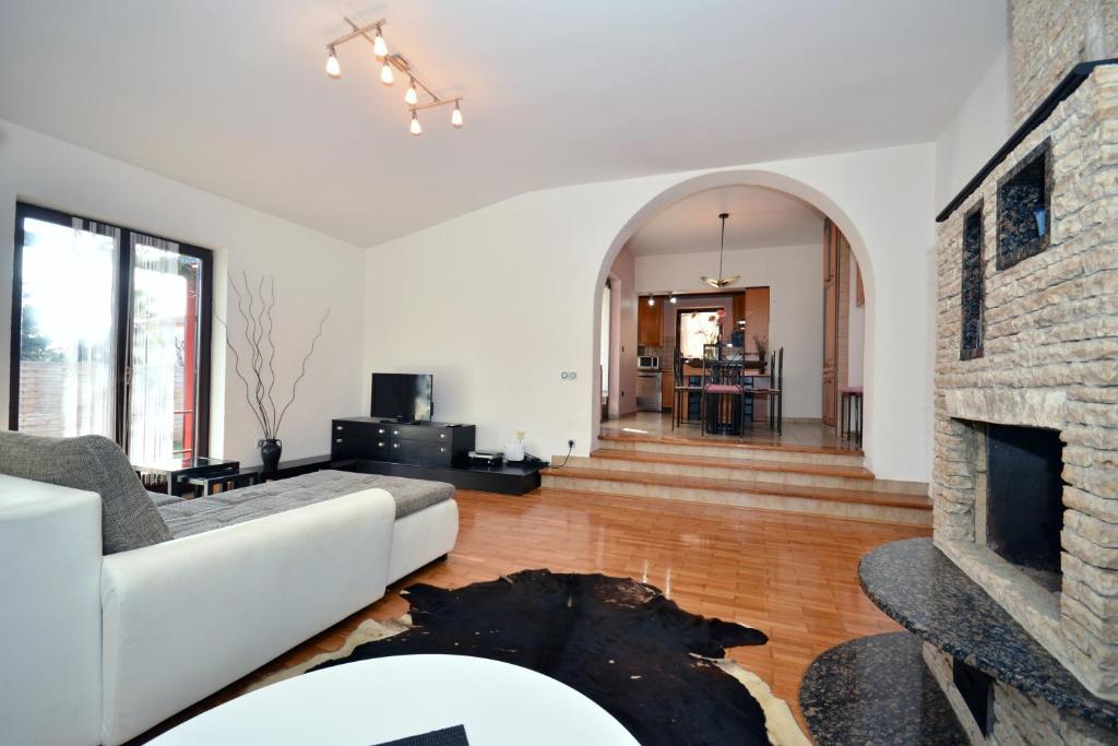 sala de estar con sofá blanco y chimenea en Apartments Jasminka, en Medulin