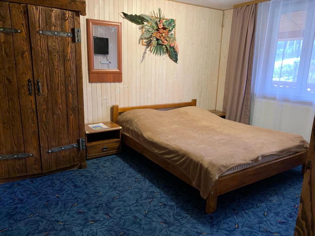 a small bedroom with a bed and a dresser at Svitlyachok in Yaremche