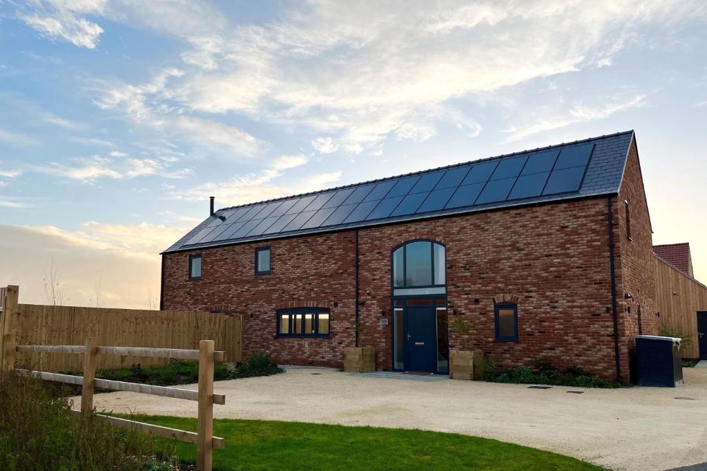 a brick building with solar panels on the roof at Walnut House, Ashlin Farm Barns in Lincoln