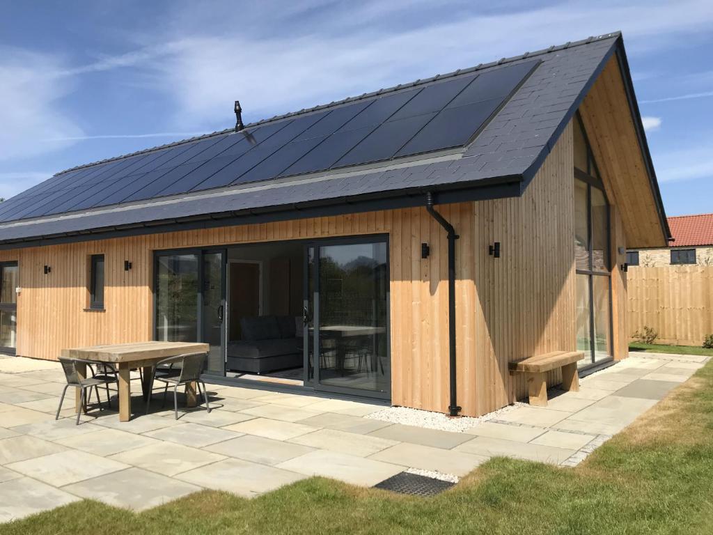 una casa con pannelli solari sul tetto di White Swan Cottage, Ashlin Farm Barns a Lincoln