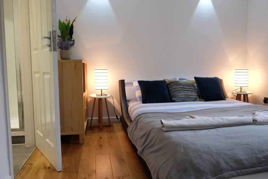 a bedroom with two beds and two lamps onlishes sidx sidx sidx sidx at Spacious two bedroom, two bathroom Beach Nest with garden in St. Leonards