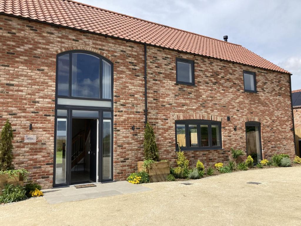 a brick building with a large glass door at The Pines, Ashlin Farm Barns in Lincoln