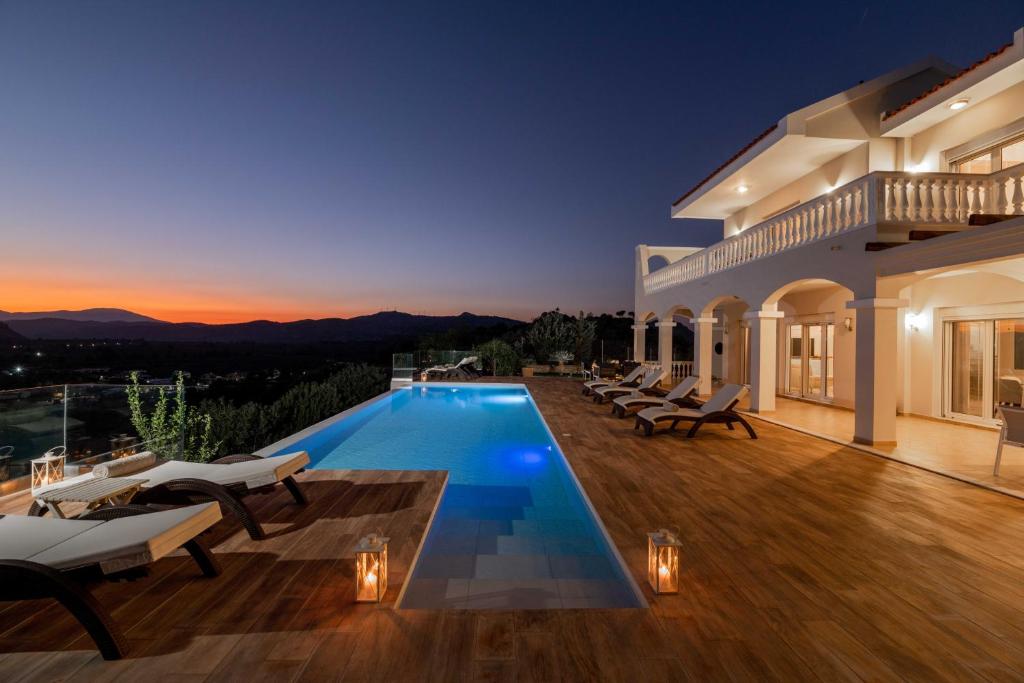 una villa con piscina por la noche en Villa Kamos, en Archangelos