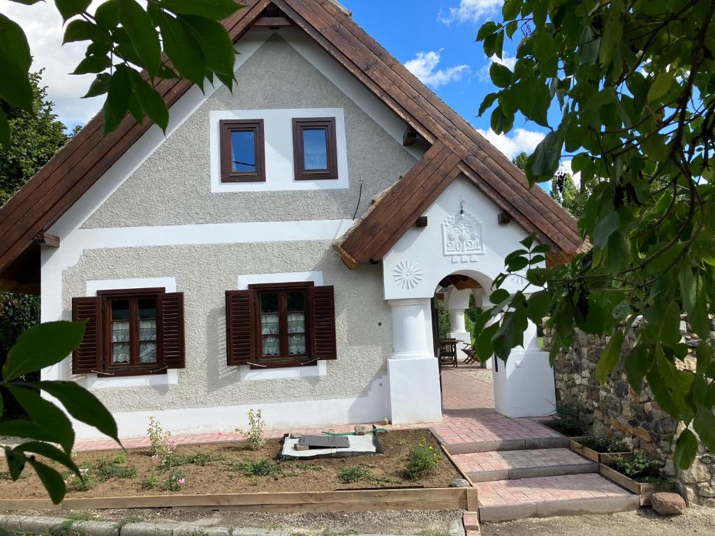 a small house with brown shutters on it at A nyugalom háza in Szentbékkálla