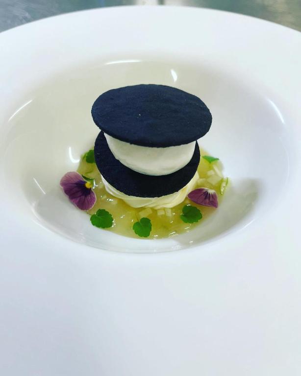 a dessert on a white plate with a black dome on top at Hôtel Le Cobh in Ploërmel