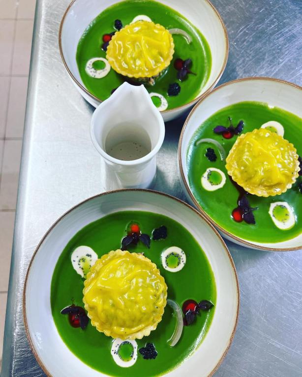 three plates of food on a tray with green dishes at Hôtel Le Cobh in Ploërmel