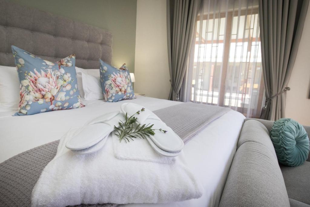 Mirihof Retreat and Olive Estate في مونتاغو: غرفة نوم عليها سرير وفوط بيضاء