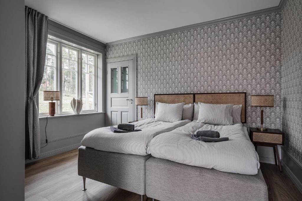1 dormitorio con 1 cama grande con sábanas blancas en Trädgårdsmästarbostaden / The Gardeners Villa, en Gävle
