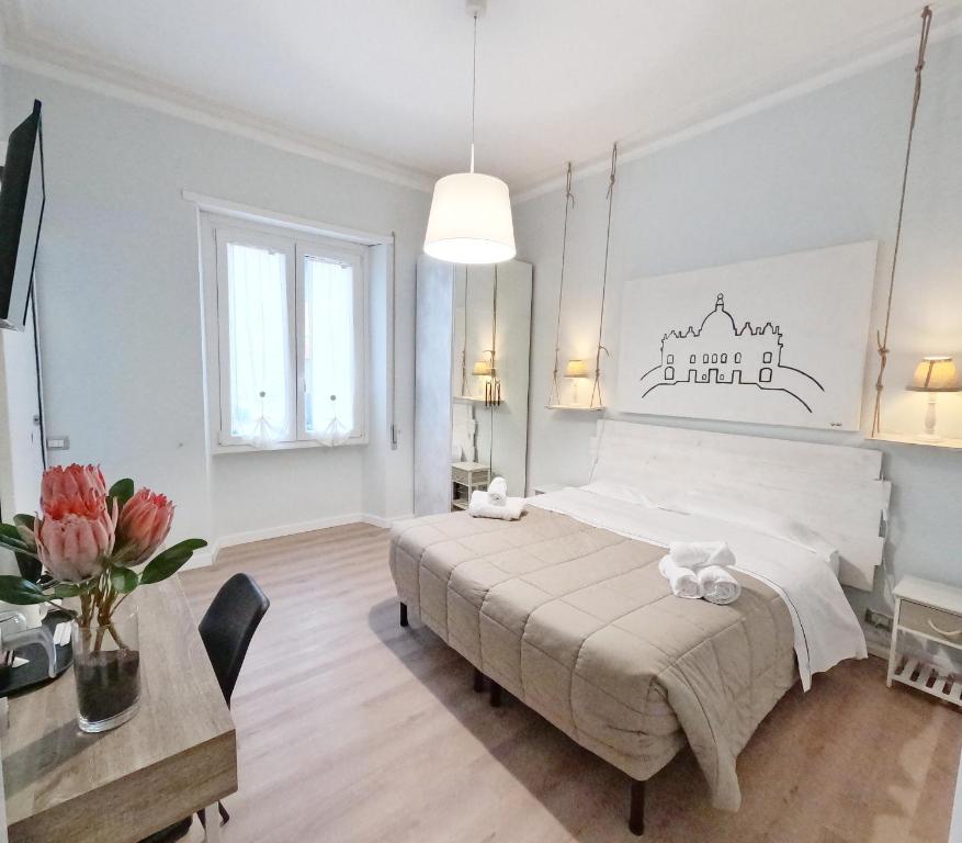 - une chambre avec un grand lit et une table fleurie dans l'établissement B&B Aurelia Garden Rooms, à Rome