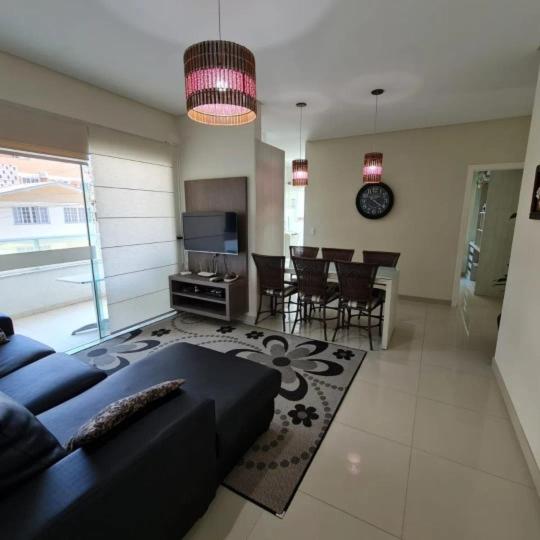 sala de estar con sofá y comedor en novo e aconchegante apartamento a 90 metros da praia de bombinhas, en Bombinhas