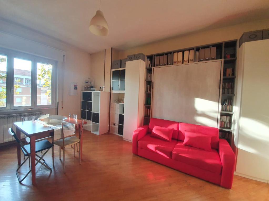 a living room with a red couch and a table at Ferrari House in Rome