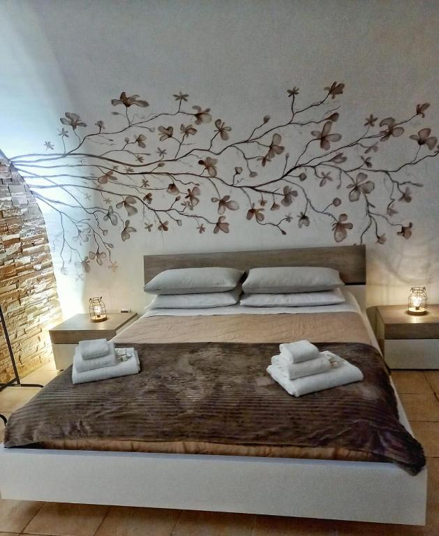 a bedroom with a bed with a tree mural on the wall at Dimora Santa Caterina in Altamura