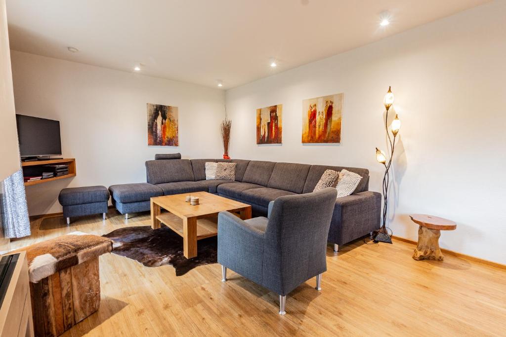 a living room with a couch and a table at Chalet Hohe Tauern - Steinbock Lodges in Zell am See