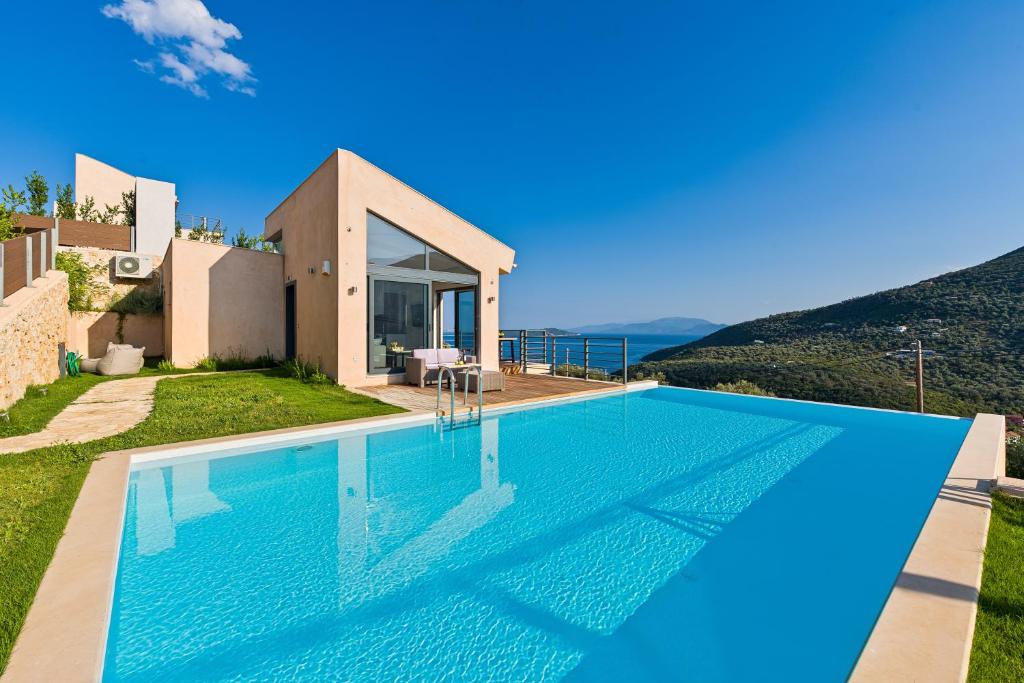 a villa with a swimming pool with a view at The Dynasty Villas in Sivota