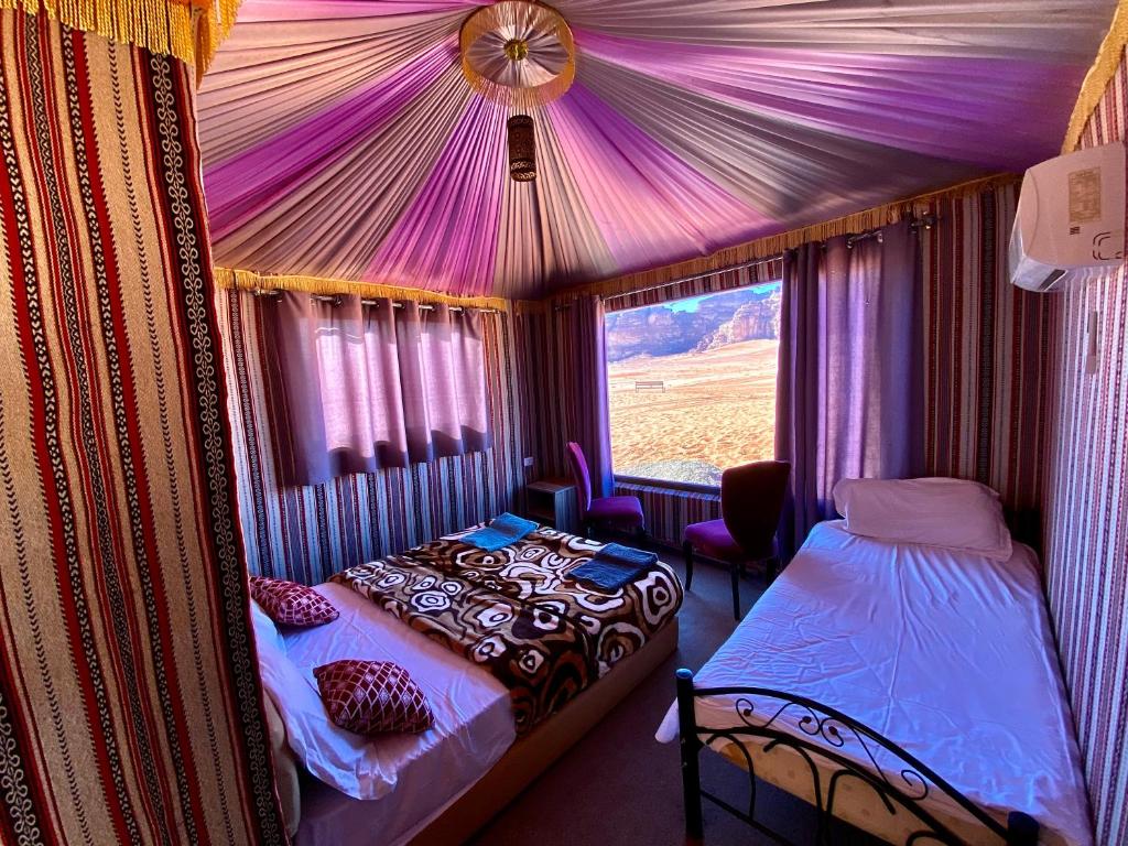 a bedroom with a tent with a bed and a window at Rum Kingdom Camp in Wadi Rum