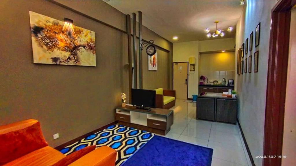 a room with a bed and a desk with a television at GWE Homestay in Bayou Lagoon Waterpark Resort Melaka in Malacca