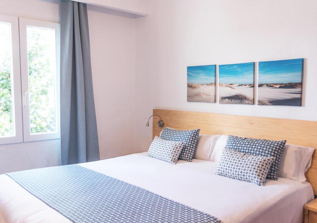 a bedroom with a bed with blue and white pillows at Comitas Tramontana Park in Fornells