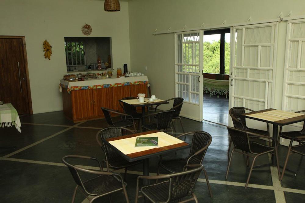 um restaurante com mesas e cadeiras num quarto em Eco Pousada Sinimbu em Cáceres