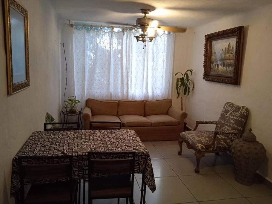 sala de estar con sofá y mesa en Departamento los Mangos, en Puerto Vallarta