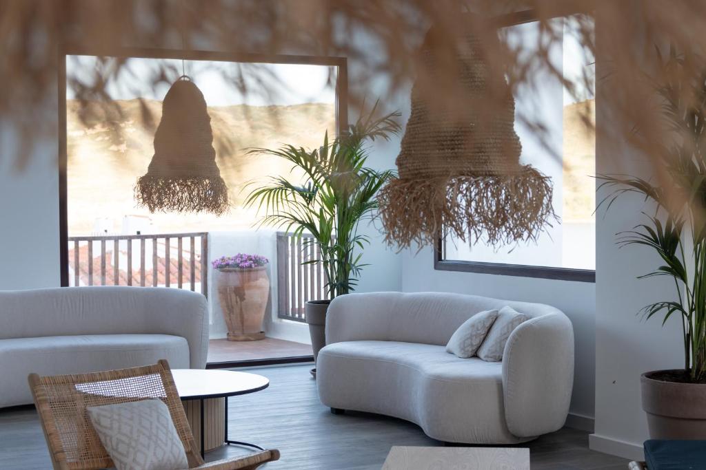 a living room with two white couches and plants at Comitas Tramontana Park in Fornells