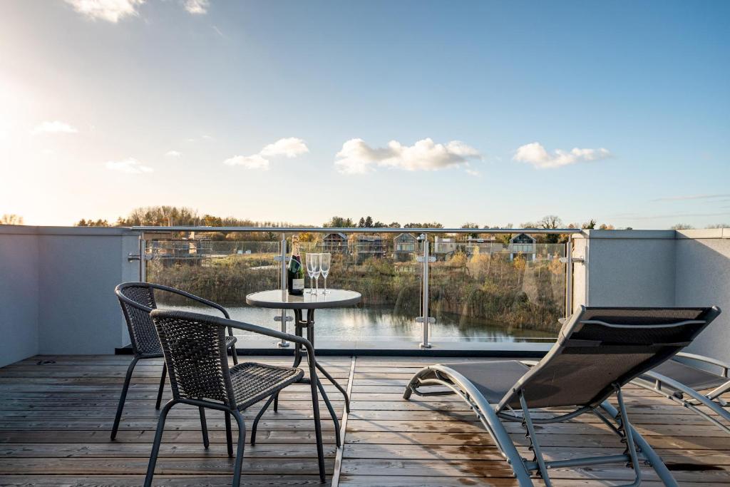 a patio with a table and chairs on a balcony at Family friendly property in nature reserve The Hangout ML15 in Somerford Keynes