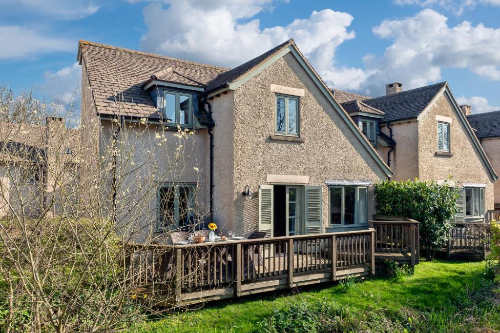 a house with a large deck on a lawn at Family friendly property in a nature reserve The Mallards MV53 in Somerford Keynes