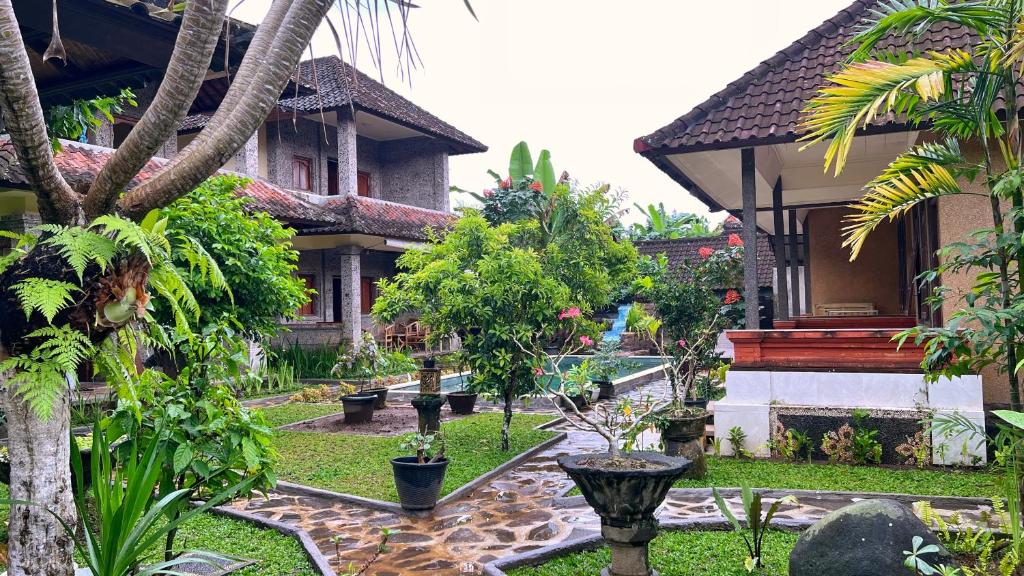 einen Innenhof eines Hauses mit Bäumen und Pflanzen in der Unterkunft Gusti Home Stay Ubud in Ubud