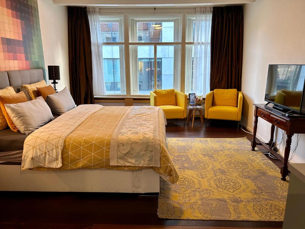 a hotel room with a bed and a tv and windows at Amsterdam 4 Holiday GuestRooms in Amsterdam