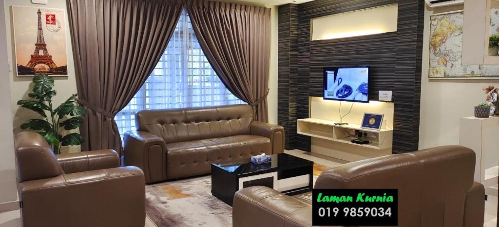 a living room with a couch and a television at Laman Kurnia Holiday House in Kota Bharu