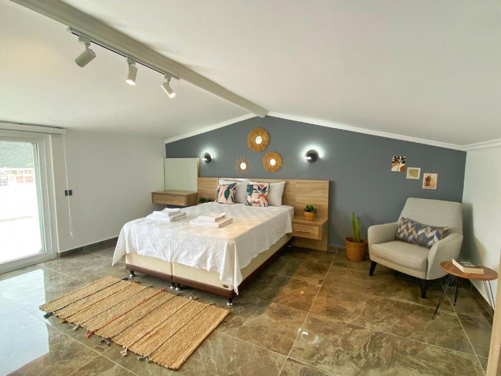 een slaapkamer met een bed en een stoel erin bij Shared Pool Flat Located 3 Min to Beach in Kalkan in Kalkan