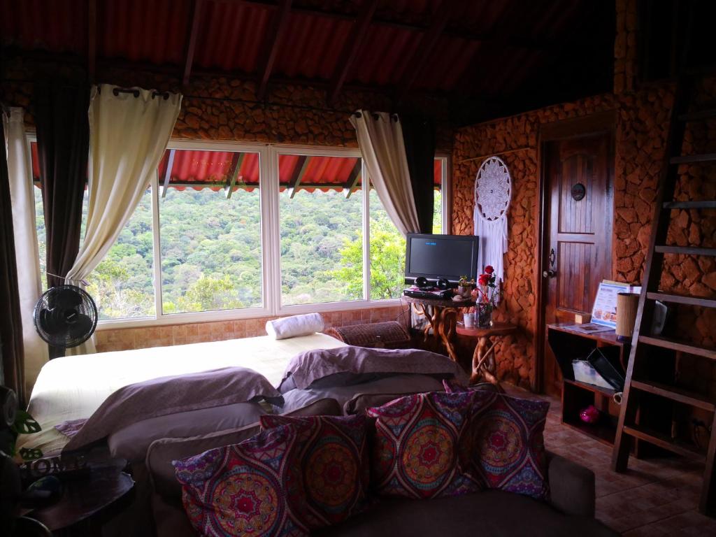 a bedroom with two beds and a large window at Mandalas Ecolodge in Cerro Azul